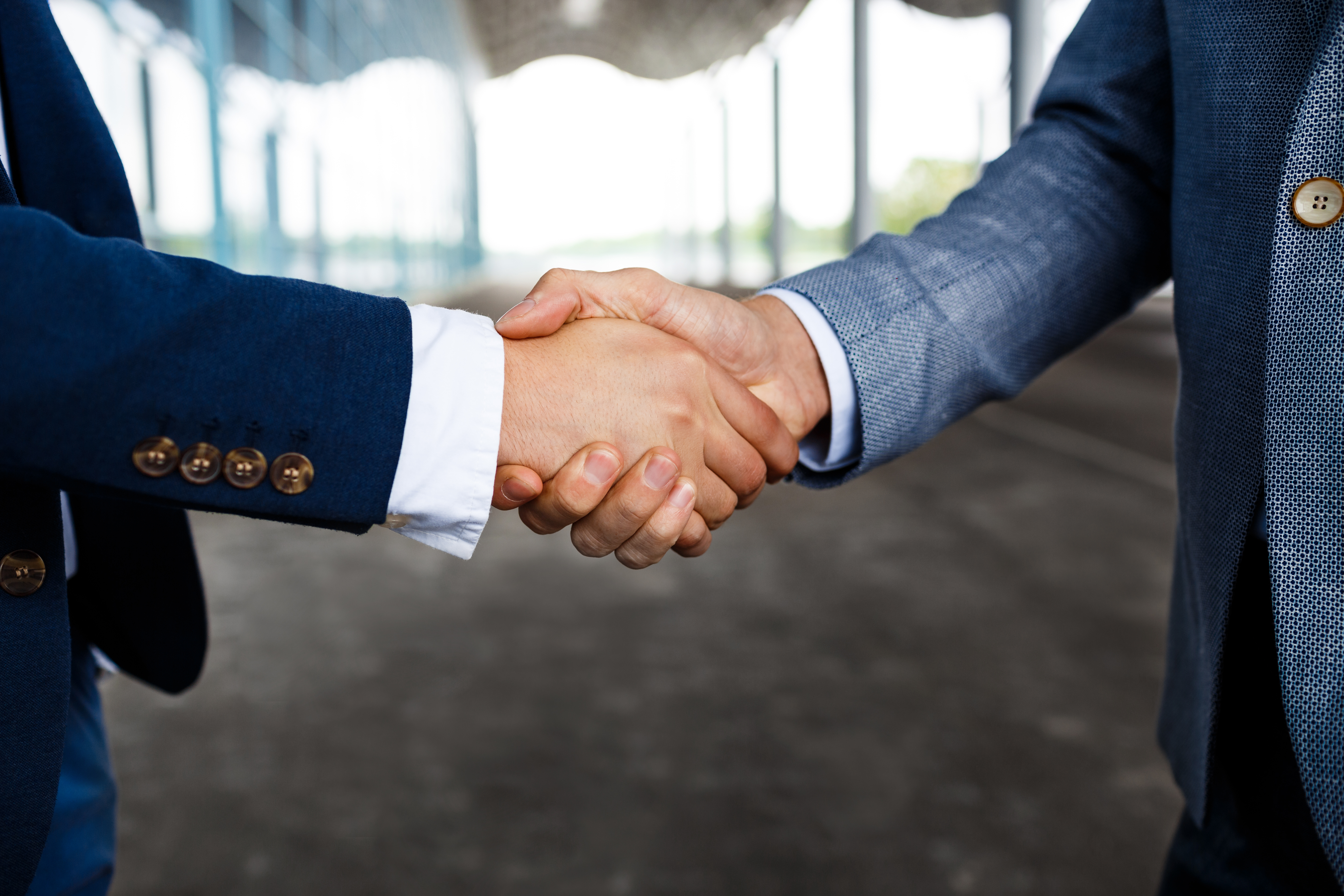Business partnership handshake with software dashboard
